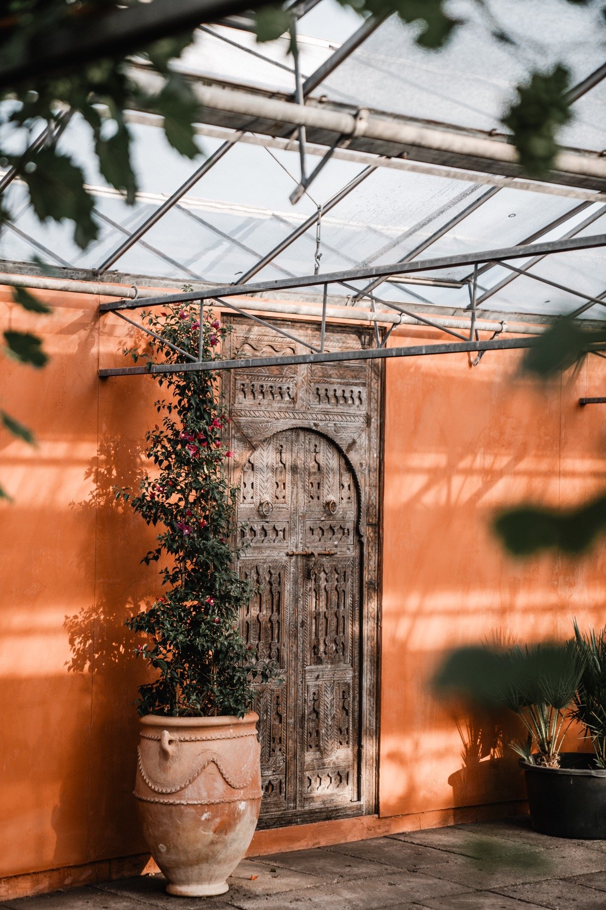 Een houten deur tegen een terracotta muur