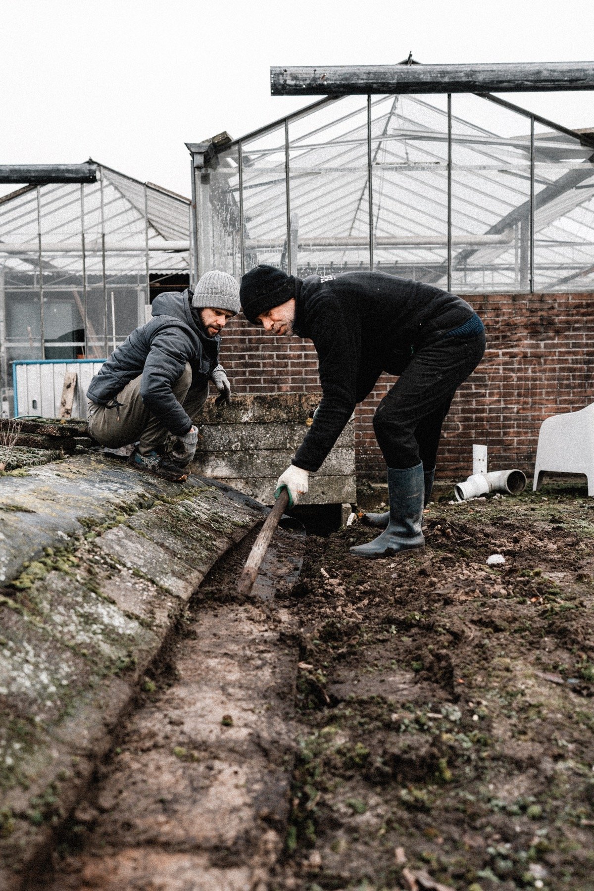 Samen oude materialen bij de kas verplaatsen